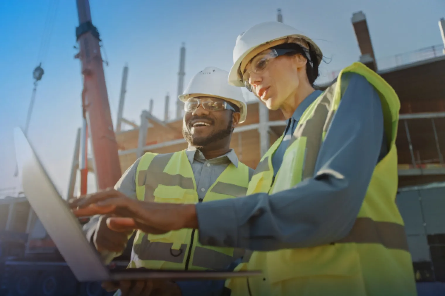Two manufacturing professionals reviewing information on a laptop