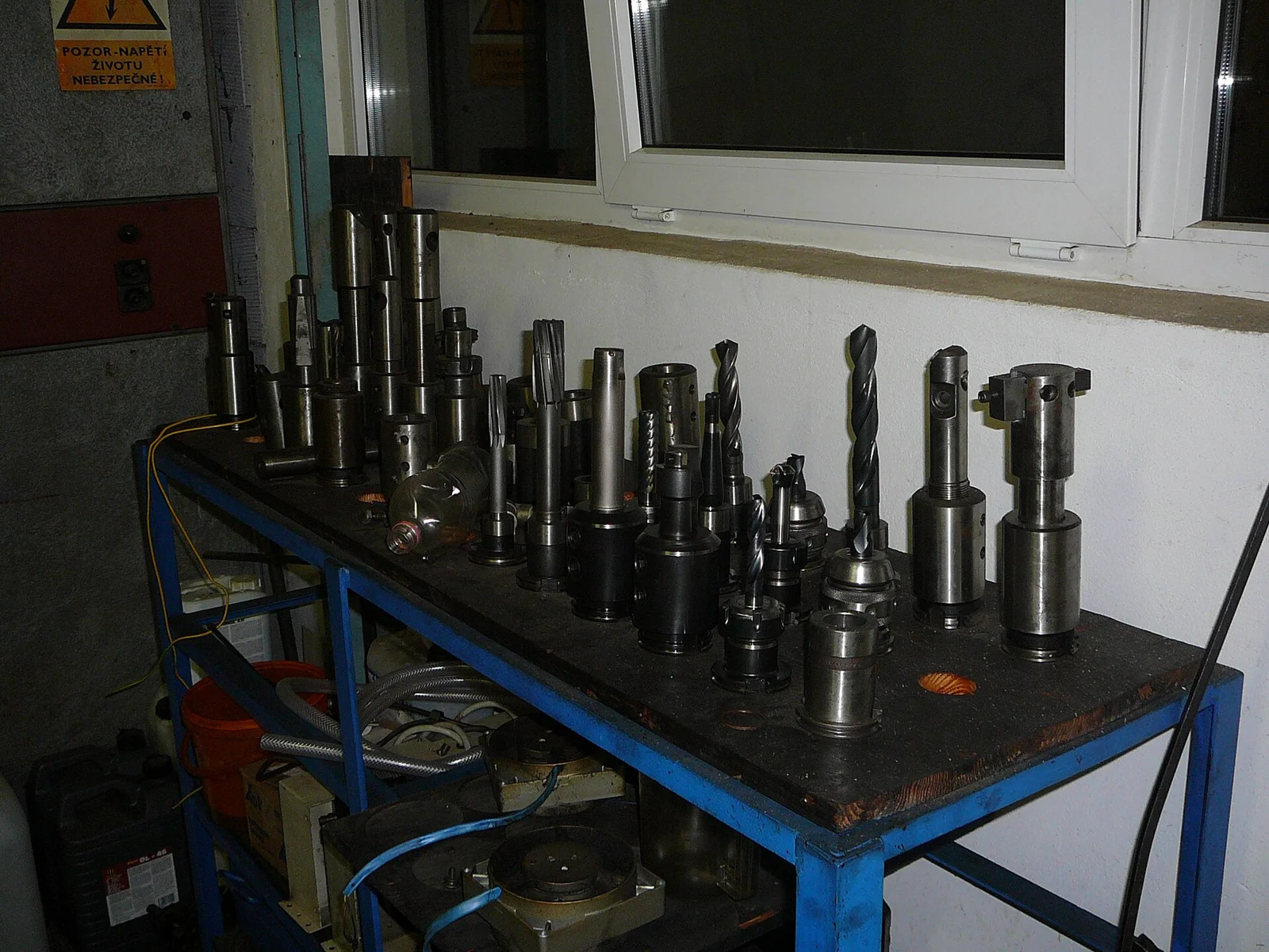 CNC tool holders and cutters arranged on a bench, the kind of real tool crib a TechDB should mirror.